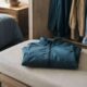 Chaqueta azul doblada con cuidado sobre un banco junto al armario.